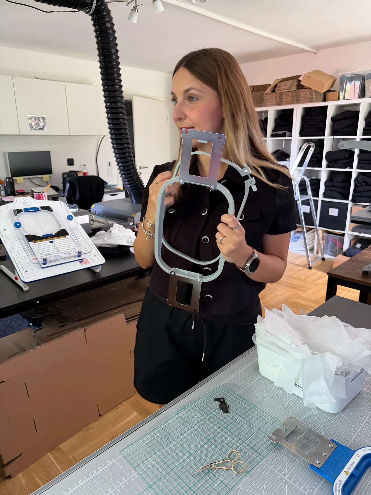 Lara Uschakow bereitet Stickrahmen, Stickvlies und Textilien für einen größeren Stickauftrag vor